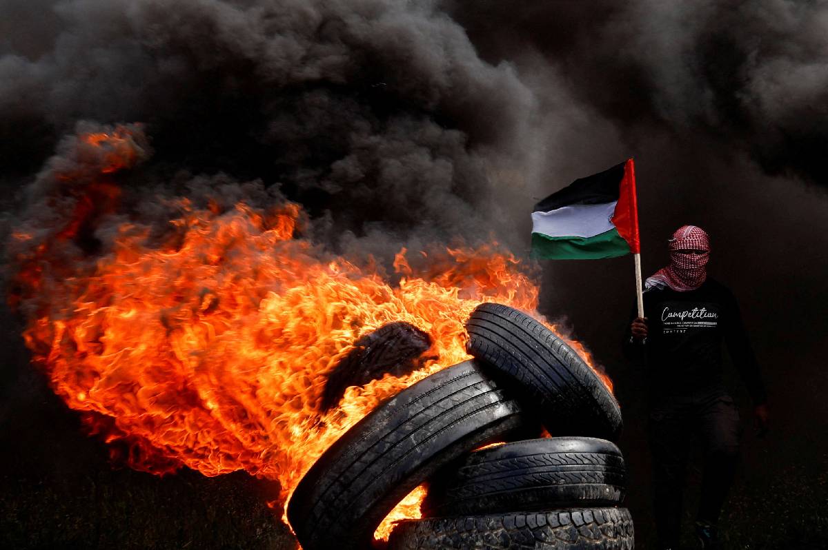 فلسطيني يحرق إطارات في غزة