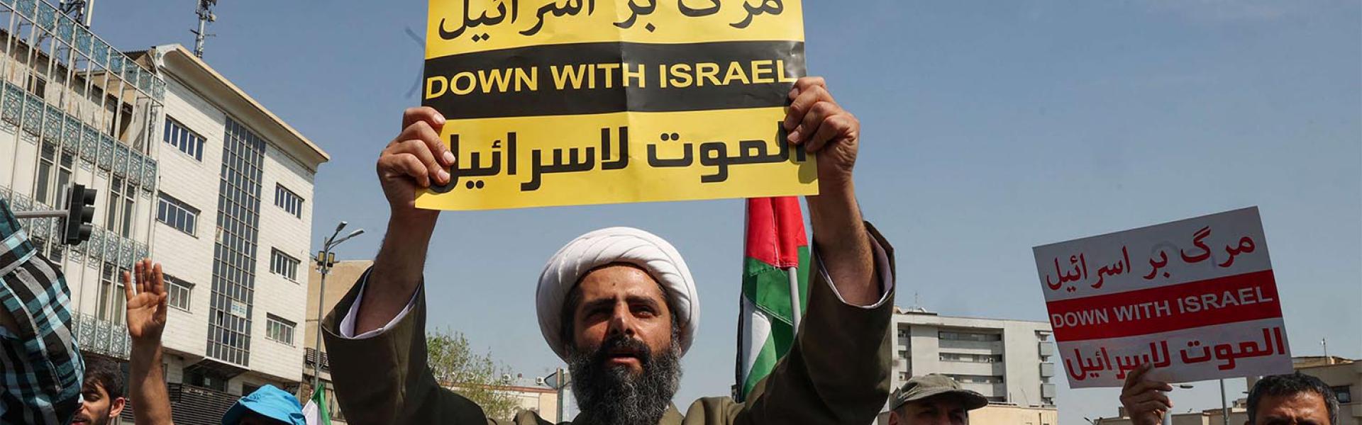 An Iranian Shiite Muslim cleric raises a placard during an anti-Israel demonstration after the Friday noon prayer in Tehran