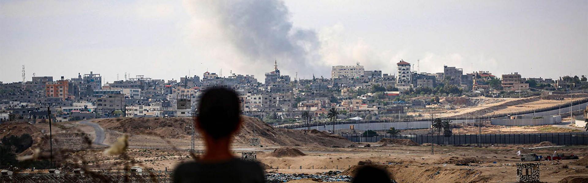 Boys watch smoke billowing during Israeli strikes east of Rafah in the southern Gaza Strip 