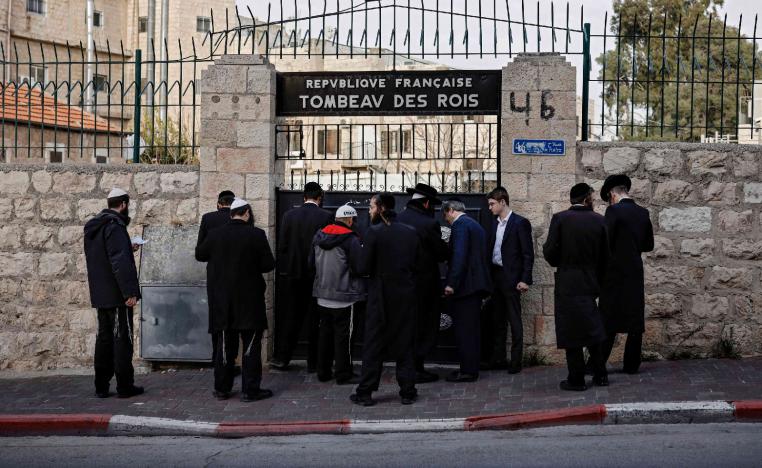 Jewish Ultra Orthodox men pray at the closed gate of the Tombs of the Kings, owned and administered by the French Consulate of Jerusalem, in east Jerusalem on January 24, 2019.