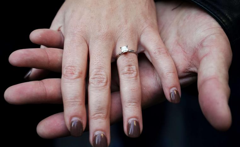 يد امرأة تلبس خاتم الزواج تمسك بيد زوجها