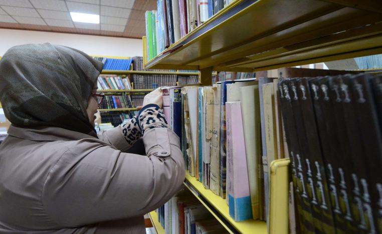 امرأة عراقية تفرز الكتب في المكتبة الجديدة لجامعة الموصل
