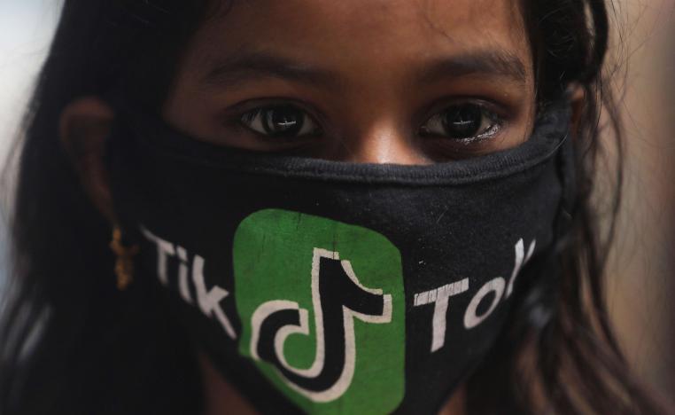 فتاة هندية ترتدي كمامة بشعار تطبيق تيك توك