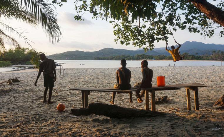 أشخاص يجلسون على شاطئ في سيراليون المطلة على المحيط الاطلسي
