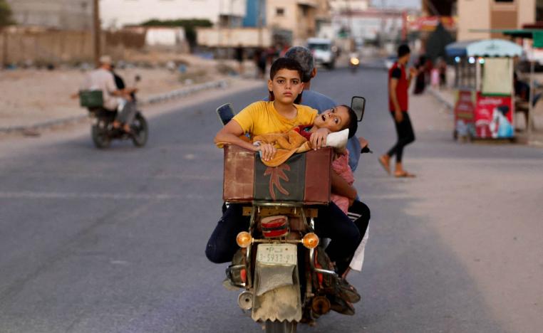 فلسطيني ينقل أولاده على دراجة نارية خلال قصف إسرائيلي على غزة