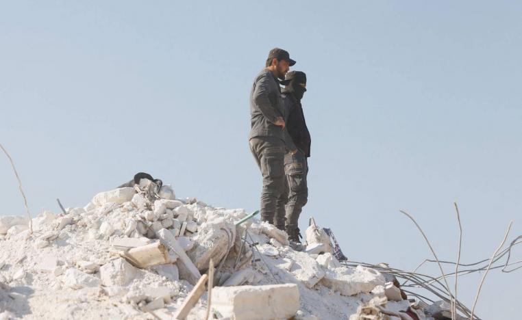سوريان يقفان على مبنى منهار في ادلب شمال سوريا