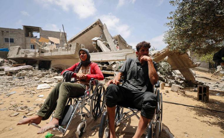 عائلة فلسطينية أمام منزلها المدمر بالقصف الإسرائيلي على غزة