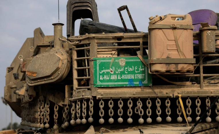 لوحة منتزعة من شارع في غزة على ظهر دبابة إسرائيلية