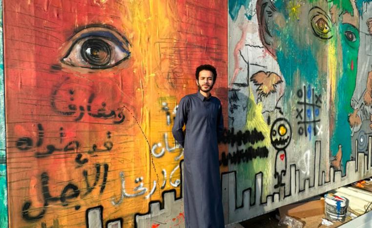فنان سعودي مع عمل تشكيلي