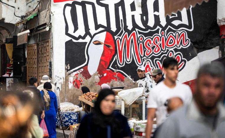 رجل مغربي يسير أمام لوحة جدارية رسمها أنصار نادي الوداد لكرة القدم، في المدينة القديمة بالدار البيضاء