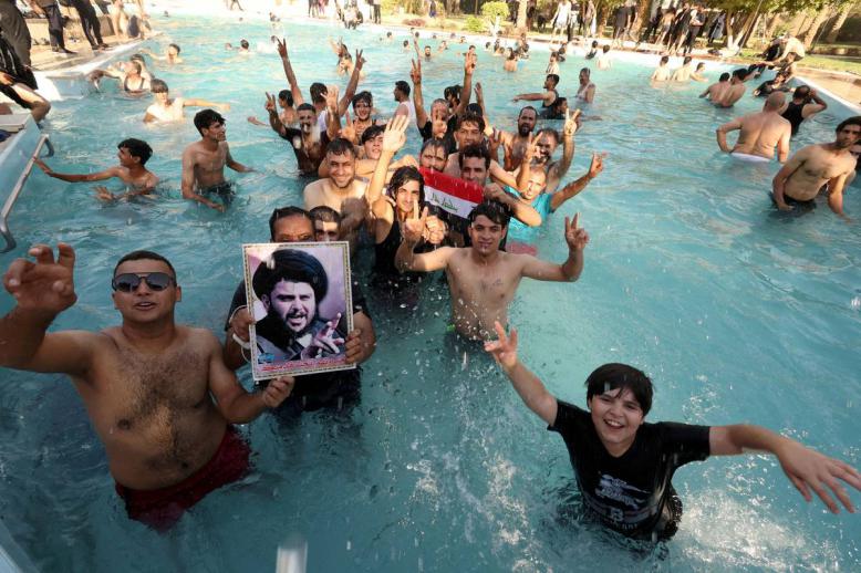 عراقيون في مسبح في بغداد يرفعون صورة لمقتدى الصدر