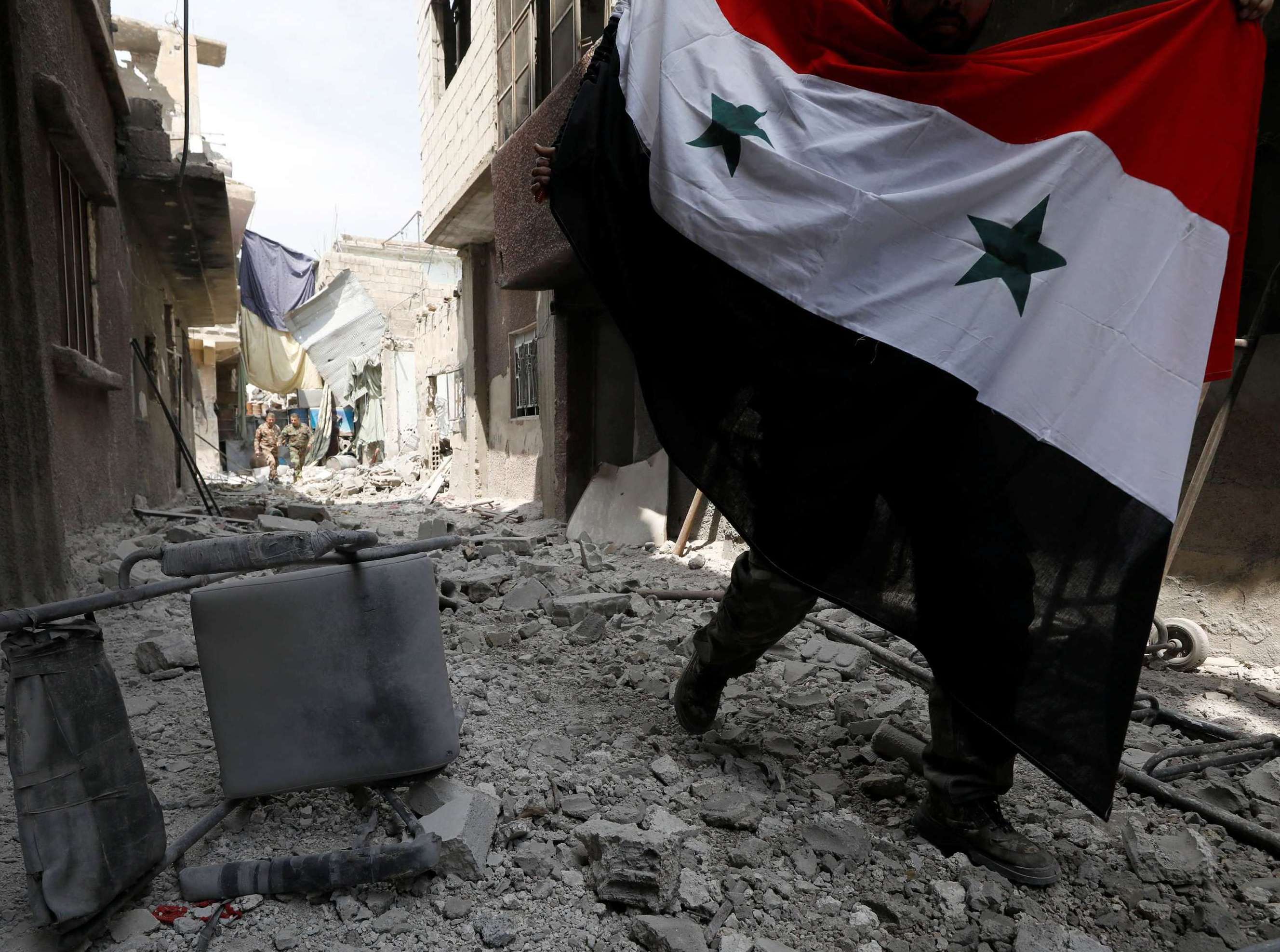 جندي سوري يرفع علم البلاد