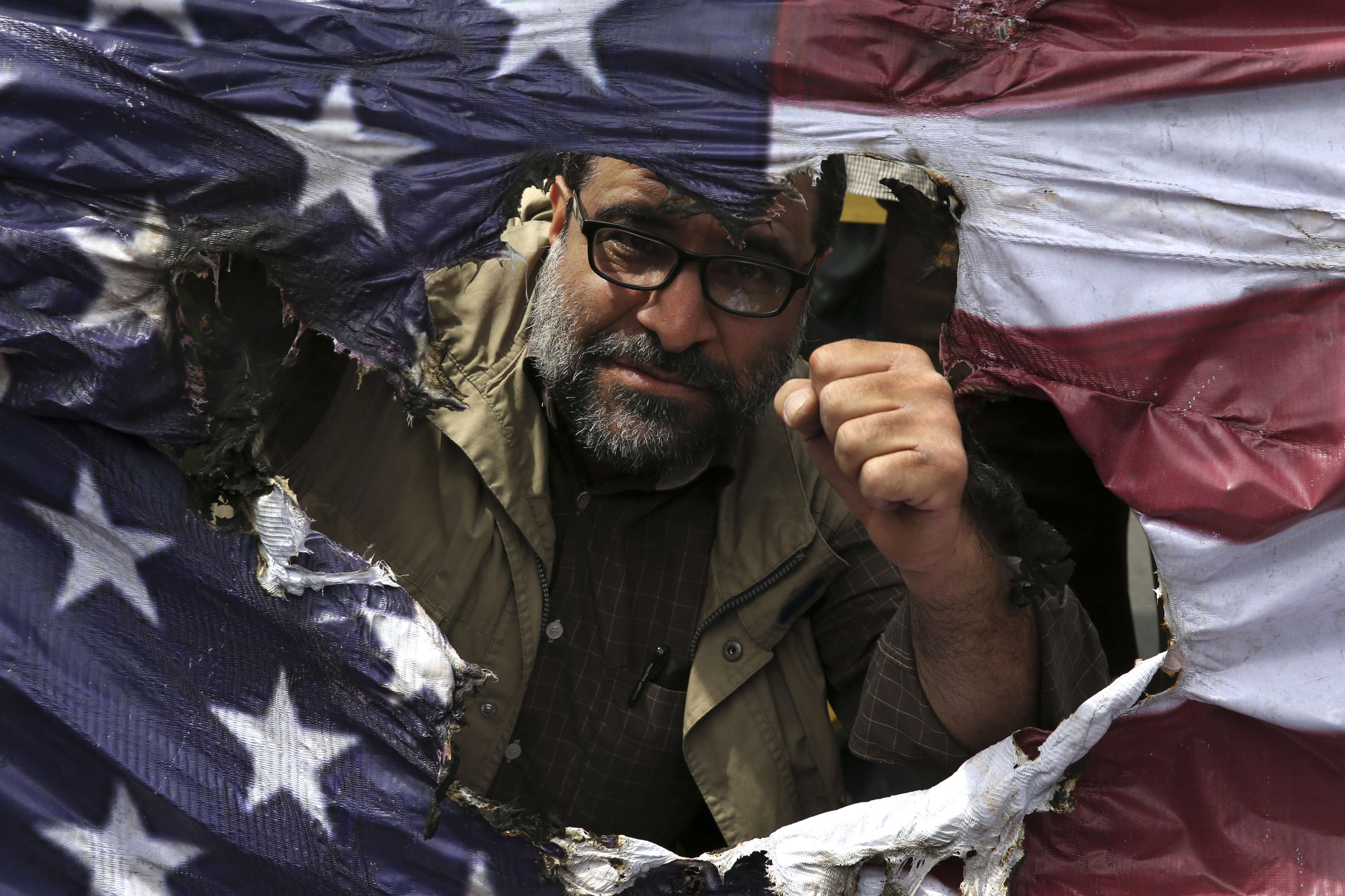 متظاهر إيراني في طهران يحرق علما أميركيا