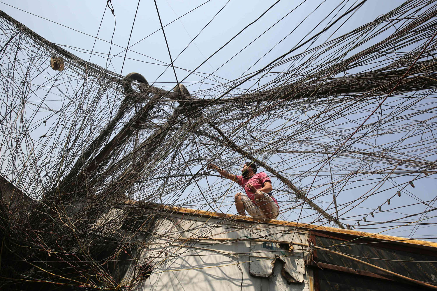عراقي يحاول العثور على التوصيلة المناسبة من شبكة الأسلاك الخاصة التي تستبدل شبكة الكهرباء الوطنية