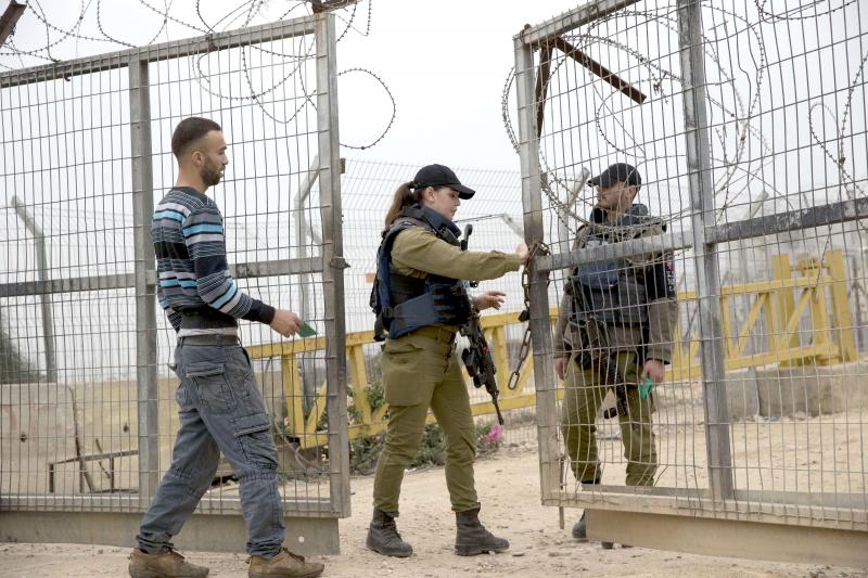 A Palestinian waits for Israeli soldiers to open the barrier gate of the to enter his farm in the village of Habla near Qalqilya