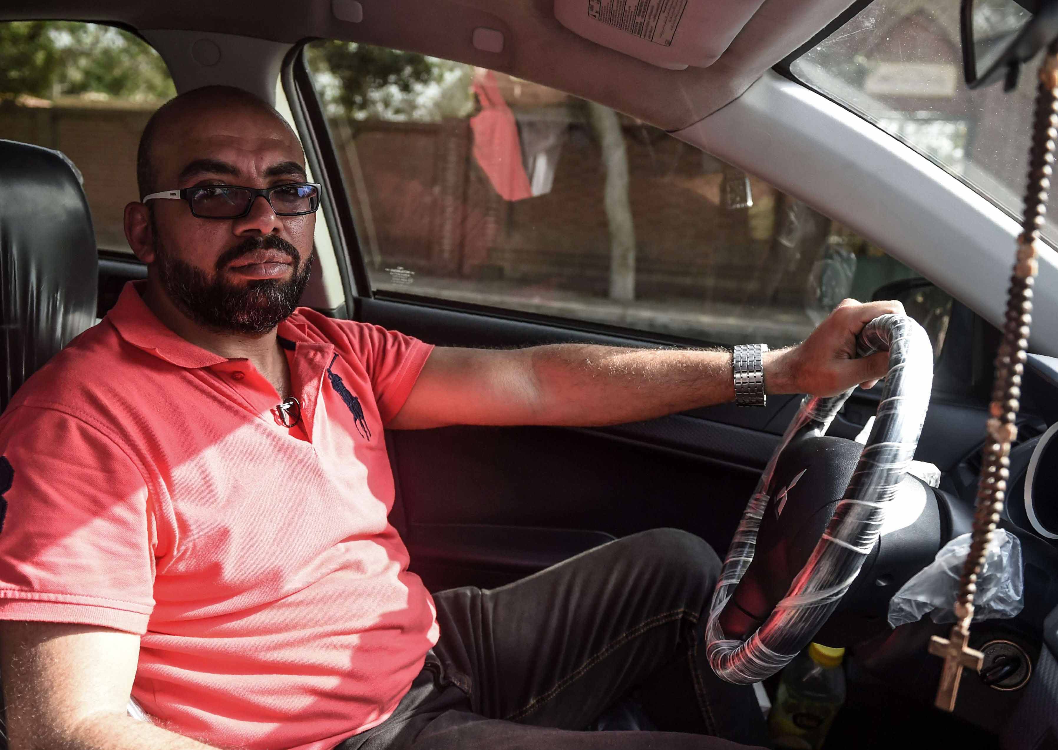رامز وجيه، محاسب في الصباح وسائق أوبر في فترة ما بعد الظهر، يقف في سيارته في القاهرة