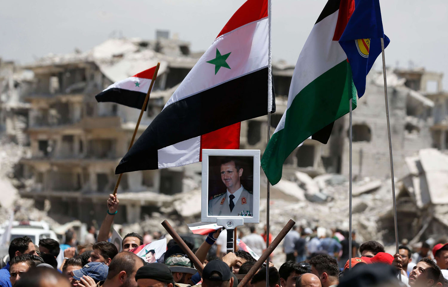 مقاتلون سوريون وفلسطينيون وإيرانيون يحتفلون بسقوط مخيم اليرموك