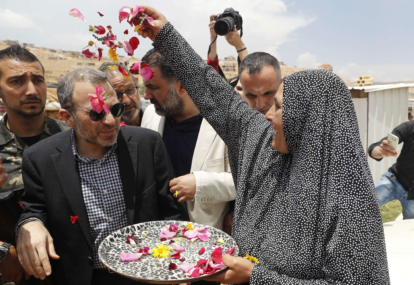 Gebran Bassil (C) is greeted with flower petals at a Syrian refugee camp in the town of Arsal on the eastern border with Syria.