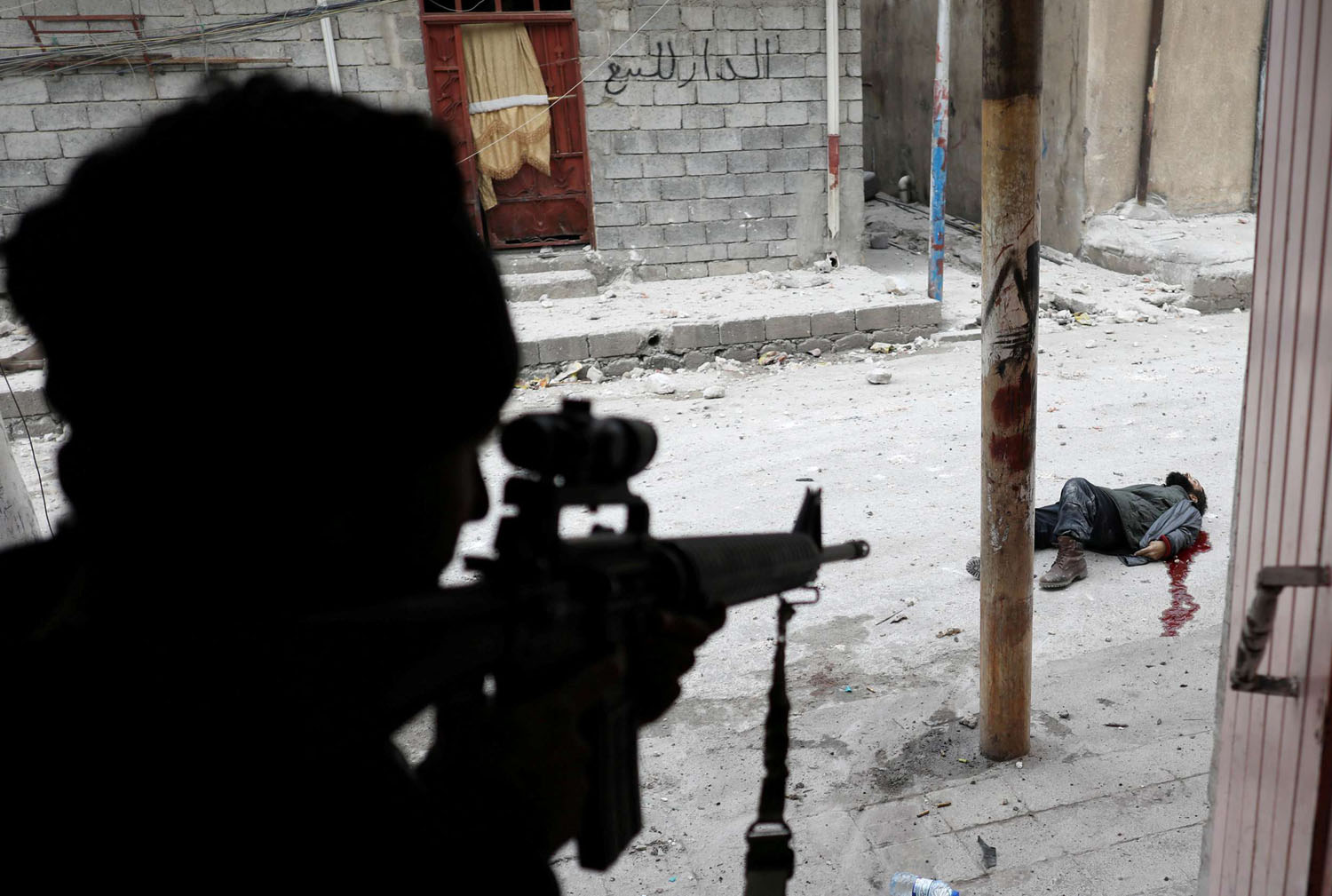 جندي عراقي بالقرب من جثة لمقاتل من داعش