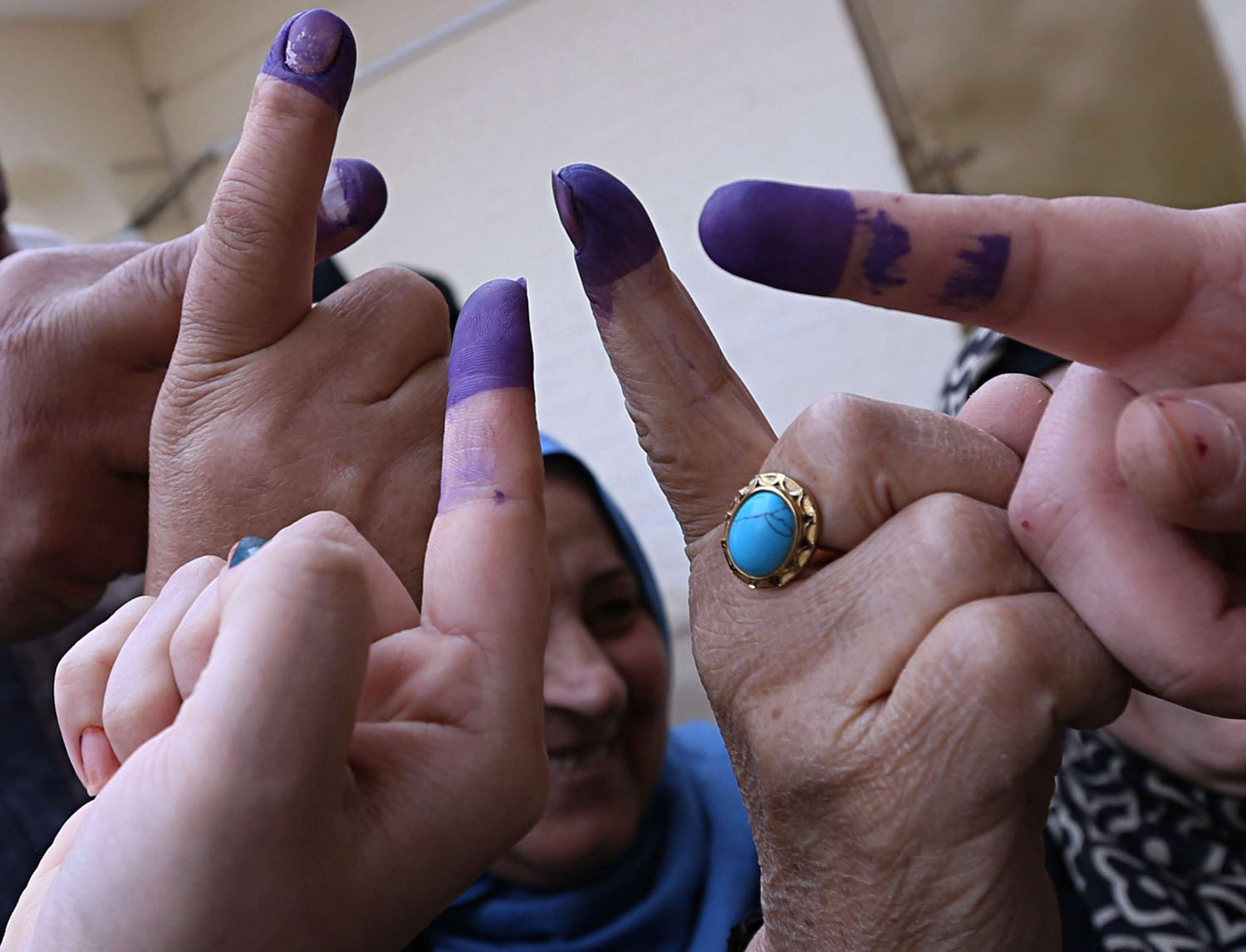 عراقيون يلوحون بأصابعهم بعد المشاركة في الانتخابات الأخيرة