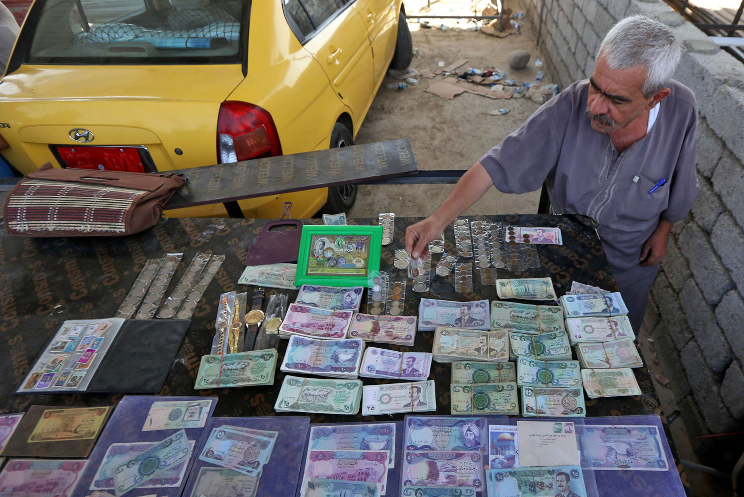 تاجر عراقي يعرض أوراق نقدية عراقية من مراحل حكم مختلفة