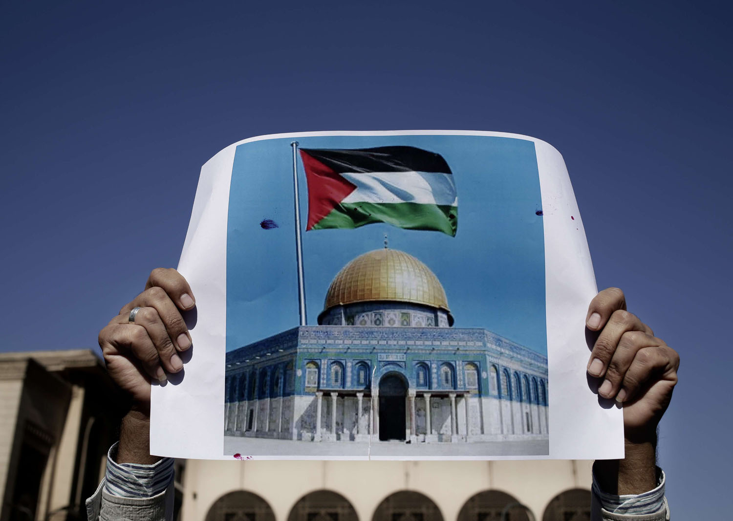 متظاهر فلسطيني يرفع صورة للقدس