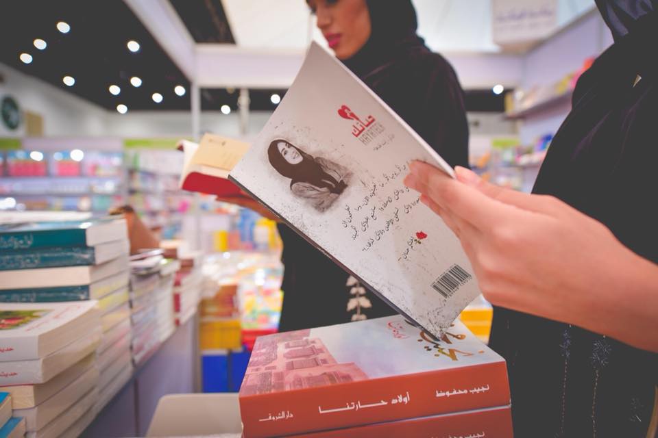 فتاة تتصفح كتابا خلال أبوظبي الدولي للكتاب 