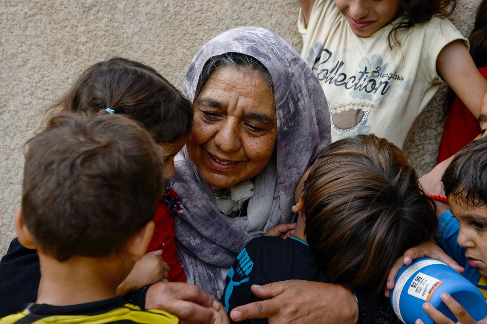 امرأة عراقية مكافحة، خيمة تظلل عائلة كبيرة من الأحفاد