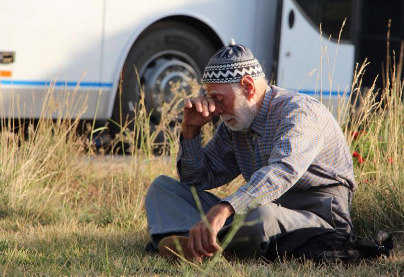 A Syrian man evacuated from the area of Fuaa and Kafraya in the Idlib province, waits outside a bus at al-Eis crossing south of Aleppo, on July 19