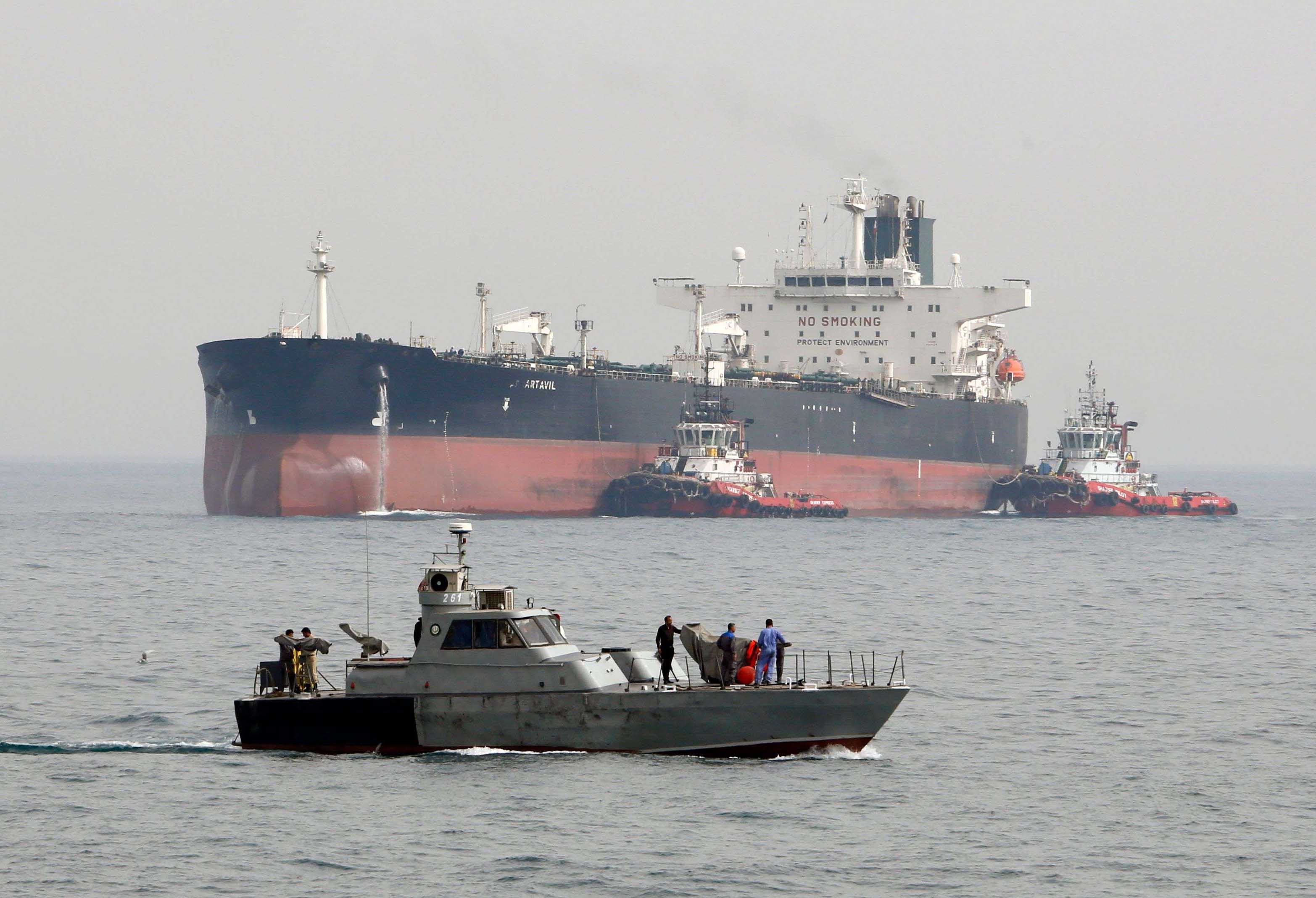 An Iranian military speedboat patrols the waters as a tanker perpares to dock at the oil facility in the Khark Island
