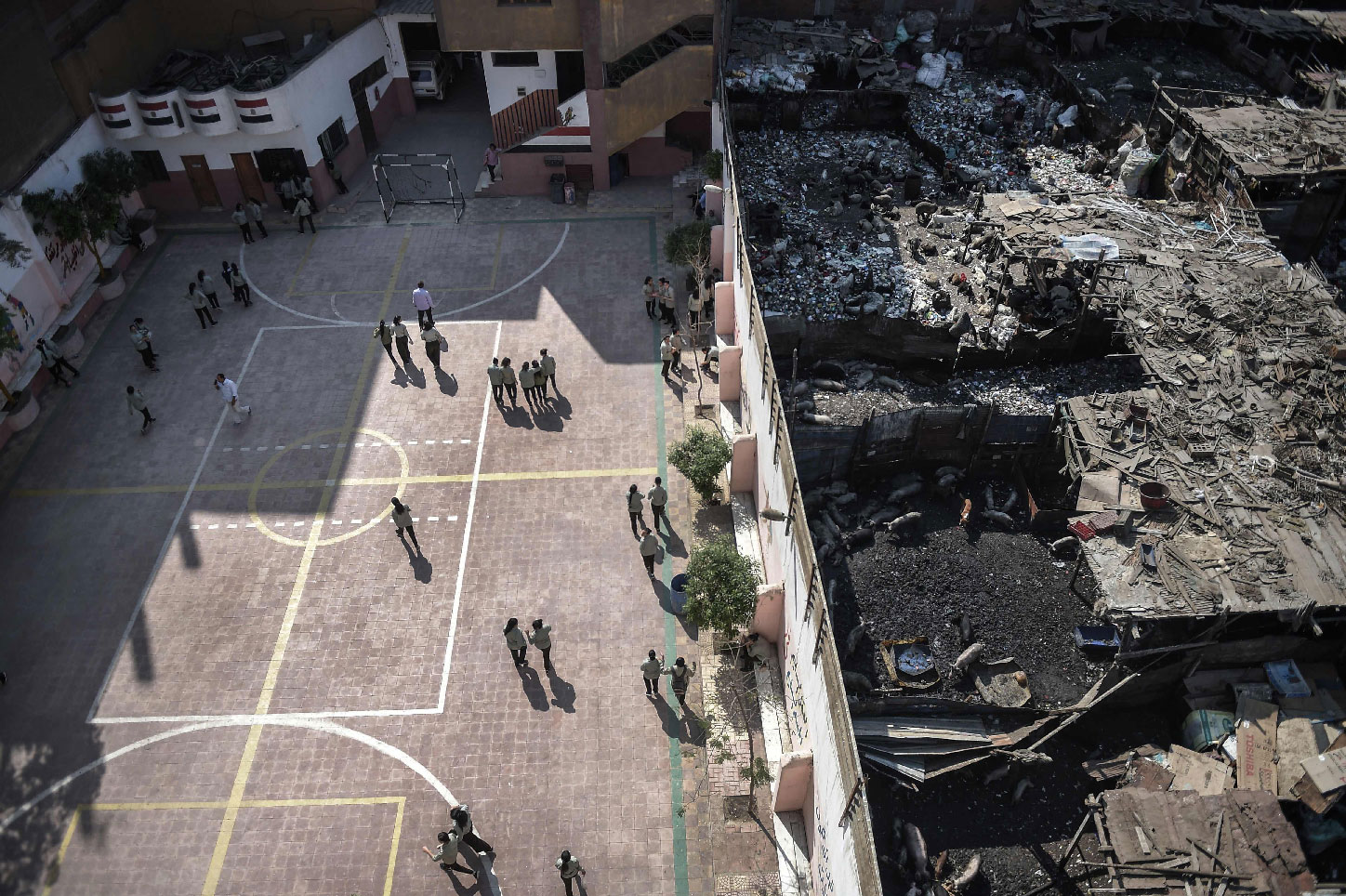 Courtyard of the Mahaba school in Ezbet al-Nakhl with a wall separating it from the shanty town in which it was built.