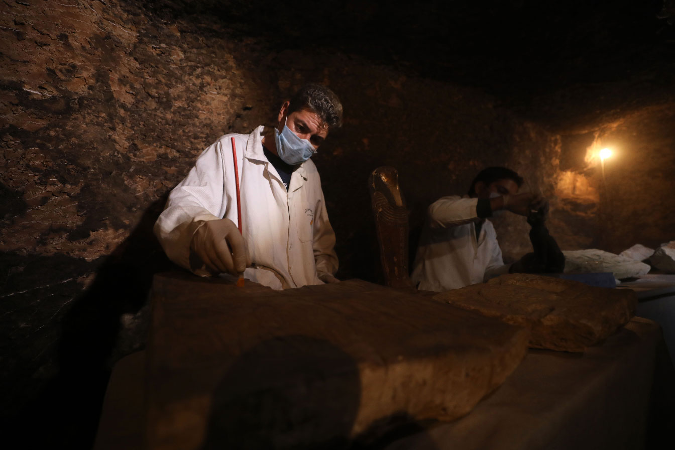 gyptian archaeologists work inside a tomb in the Saqqara necropolis.