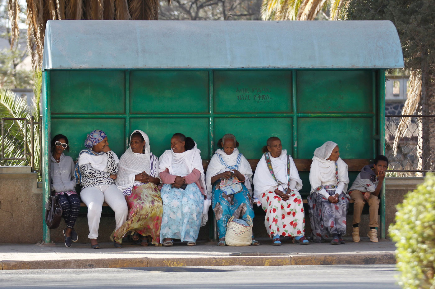 Passengers wait for the bus at a stop along a street in Asmara, Eritrea.
