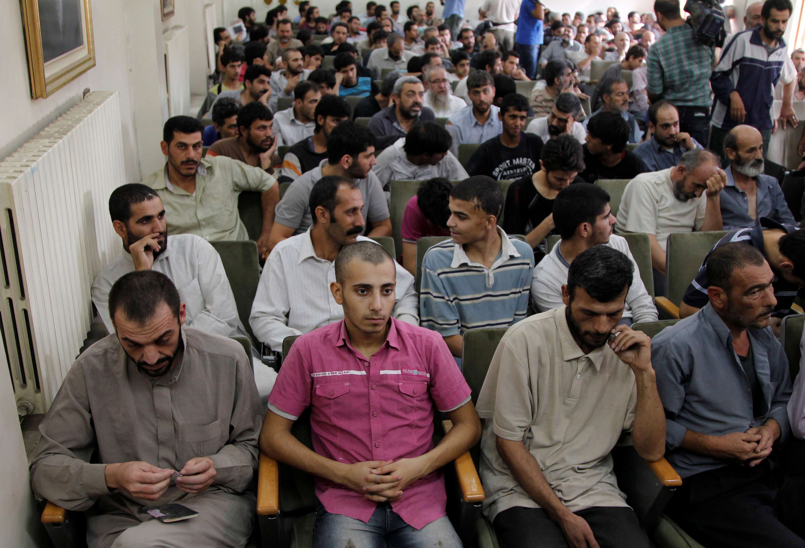 Syrian detainees, who were arrested over participation in protests against Syrian President Bashar al-Assad's regime, are seen waiting to sign their release papers at a police building in Damascus October 24, 2012. 