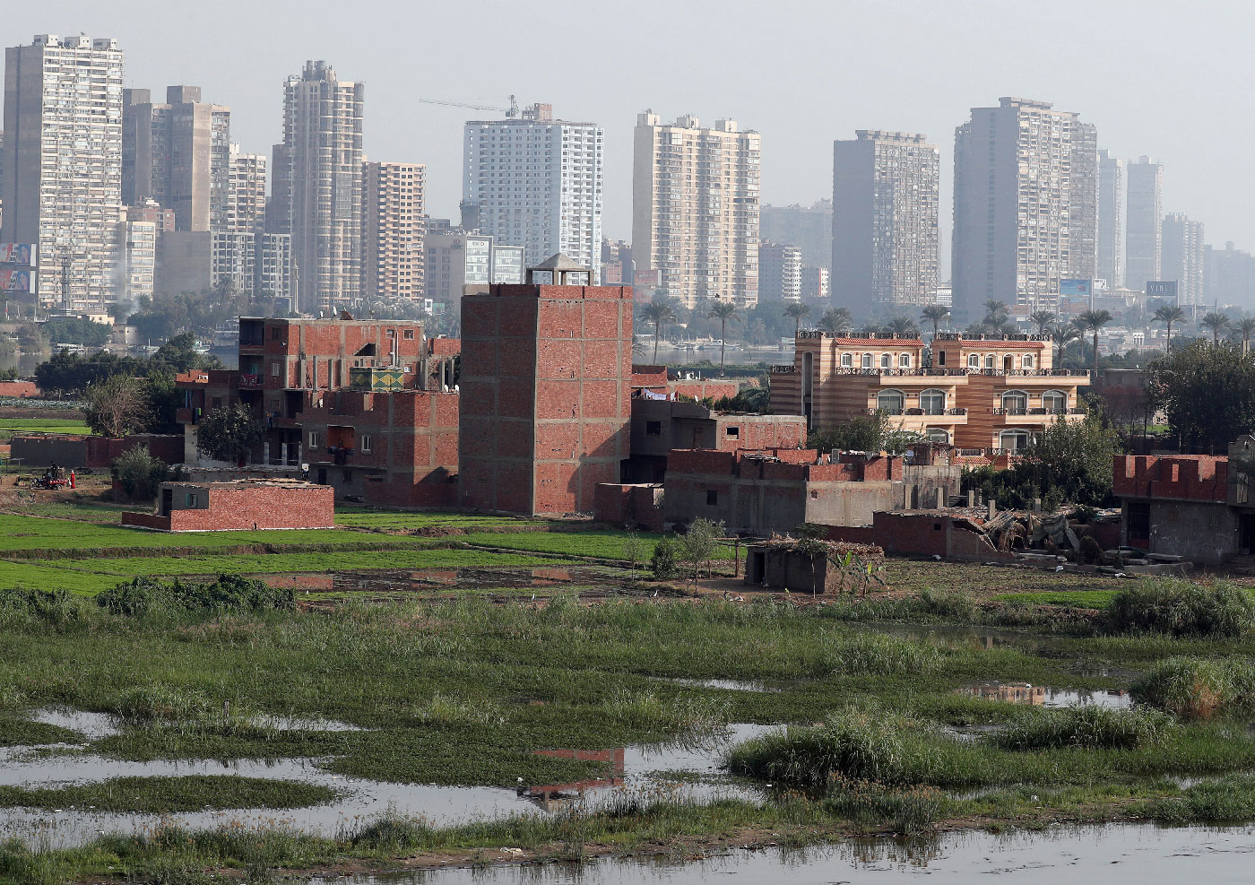 A view of houses and farmland on an island on the River Nile in front of high-rise buildings in Cairo, Egypt, November 25, 2018.