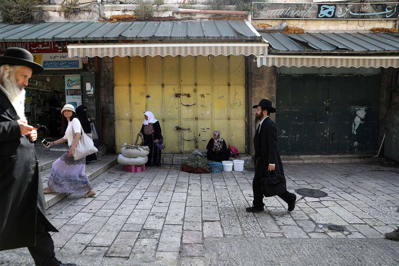 People walk past closed shops during a general strike in Jerusalem's Old City