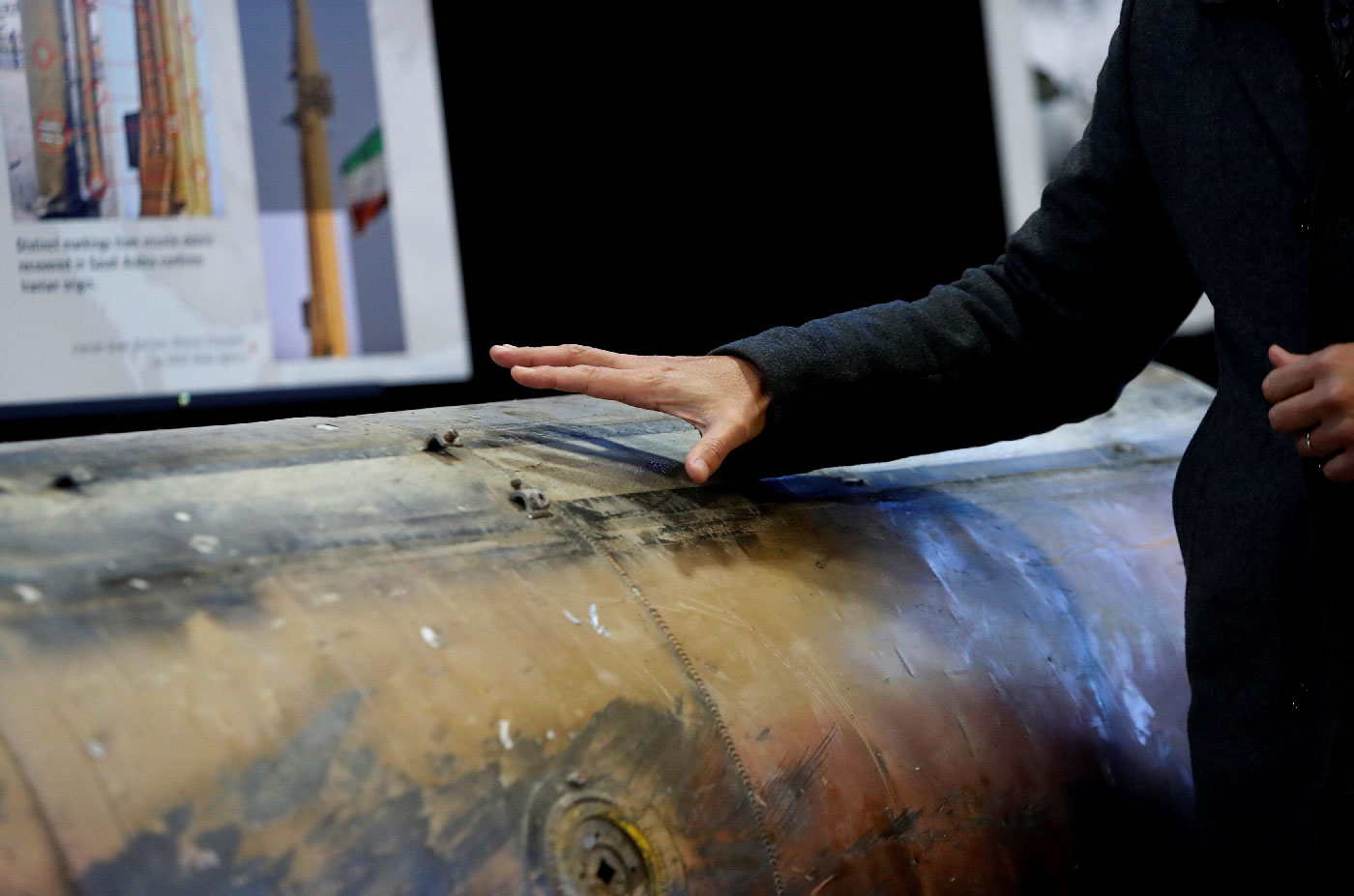 A Middle Eastern journalist touches a missile that the U.S. Defense Department says was manufactured in Iran but that they also claim was fired by Huthi rebels from Yemen into Saudi Arabia in July 2016, as it sits on display at a military base in Washington, U.S., December 13, 2017.