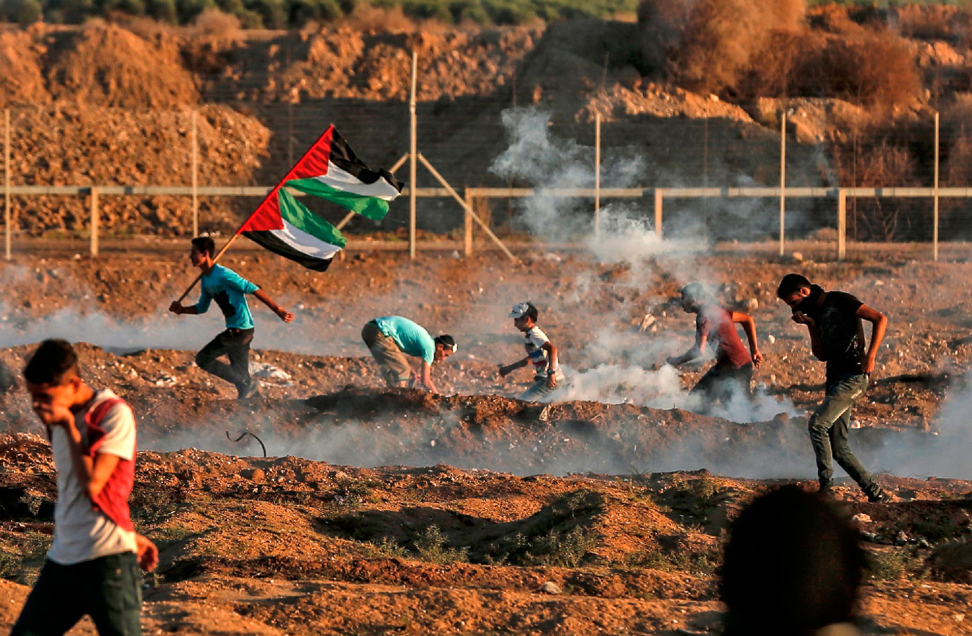 Palestinian protesters react to tear gas fired by Israeli forces during clashes east of Gaza City near the Israeli border on November 2, 2018.
