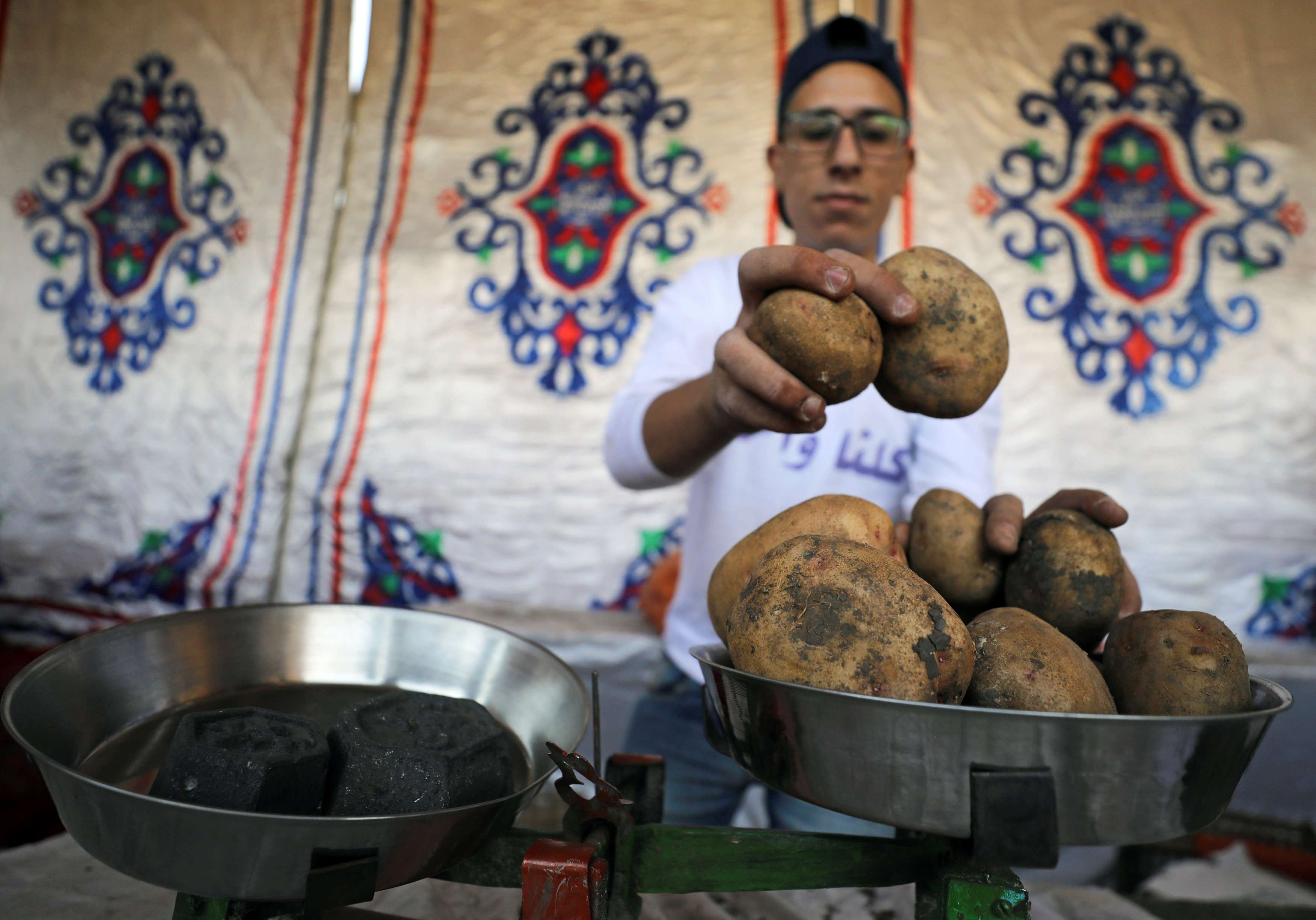 A vendor weighs potatoes at a temporary tent with government subsidised goods, after consumer prices increase across the country in Cairo, Egypt.