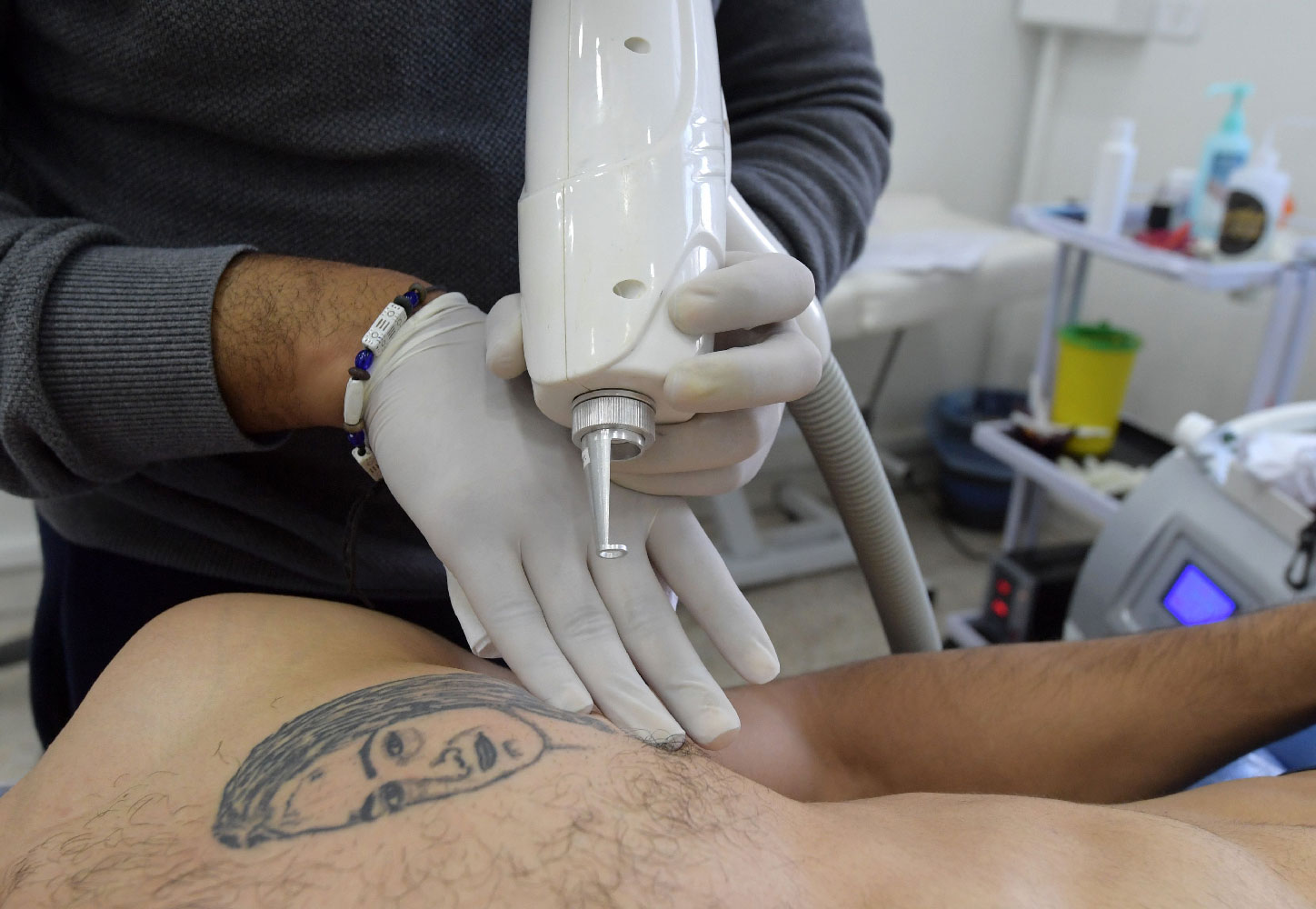 Tunisian tattoo artist Fawez Zahmoul removes a tattoo from his client in his school on November 8, 2018 in Tunis.