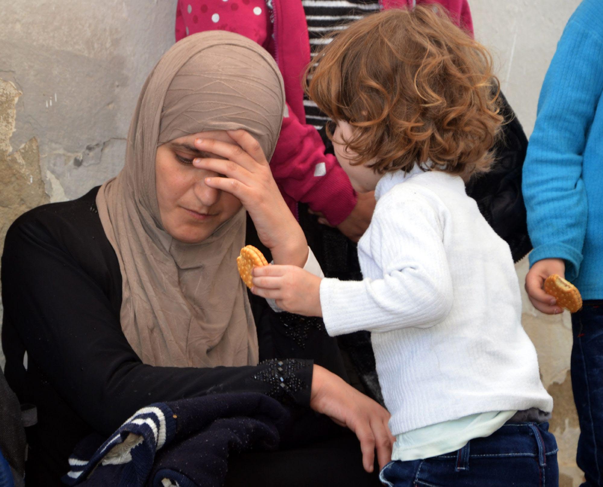 A woman migrant and her child sit at the Tunisian port of Ben Guerdane, some 40km west of the Libyan border