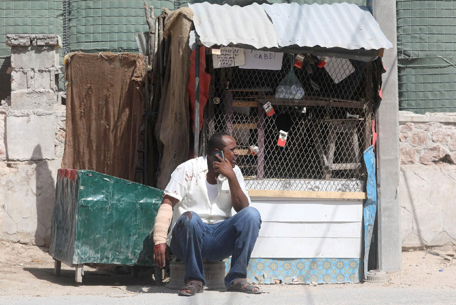 A civilian, injured following an explosion near the president's residence, uses his mobile phone as he waits for medical attention in Mogadishu, Somalia December 22, 2018.
