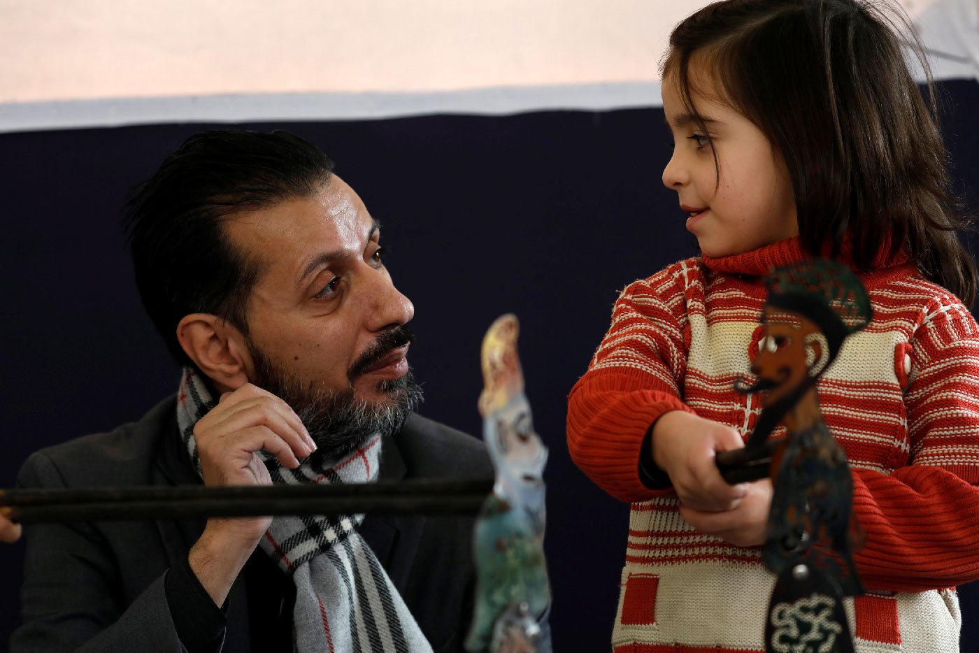 Shadi al-Hallaq, a puppeteer, is seen next to a disabled child during a performance in Damascus, Syria December 3, 2018.