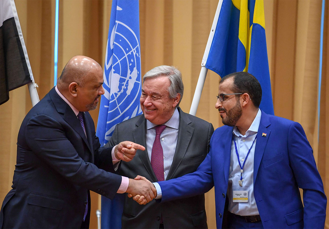 Yemen's FM Khaled al-Yamani (L) and rebel negotiator Mohammed Abdelsalam (R) shake hands