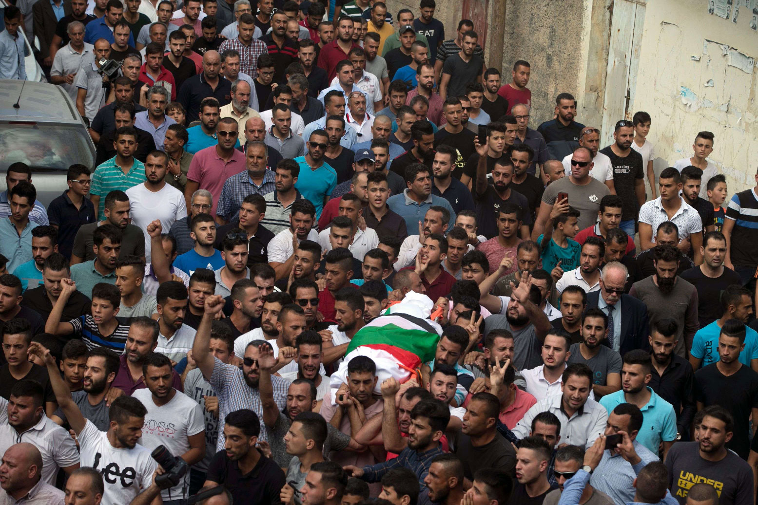 Palestinians carry the body of 48-year-old mother of eight, Aisha Rabi, who died of her wounds after the car she was travelling in with her husband was hit by stones, during her funeral in the West Bank village of Bidya, near Salfit, on October 13, 2018.