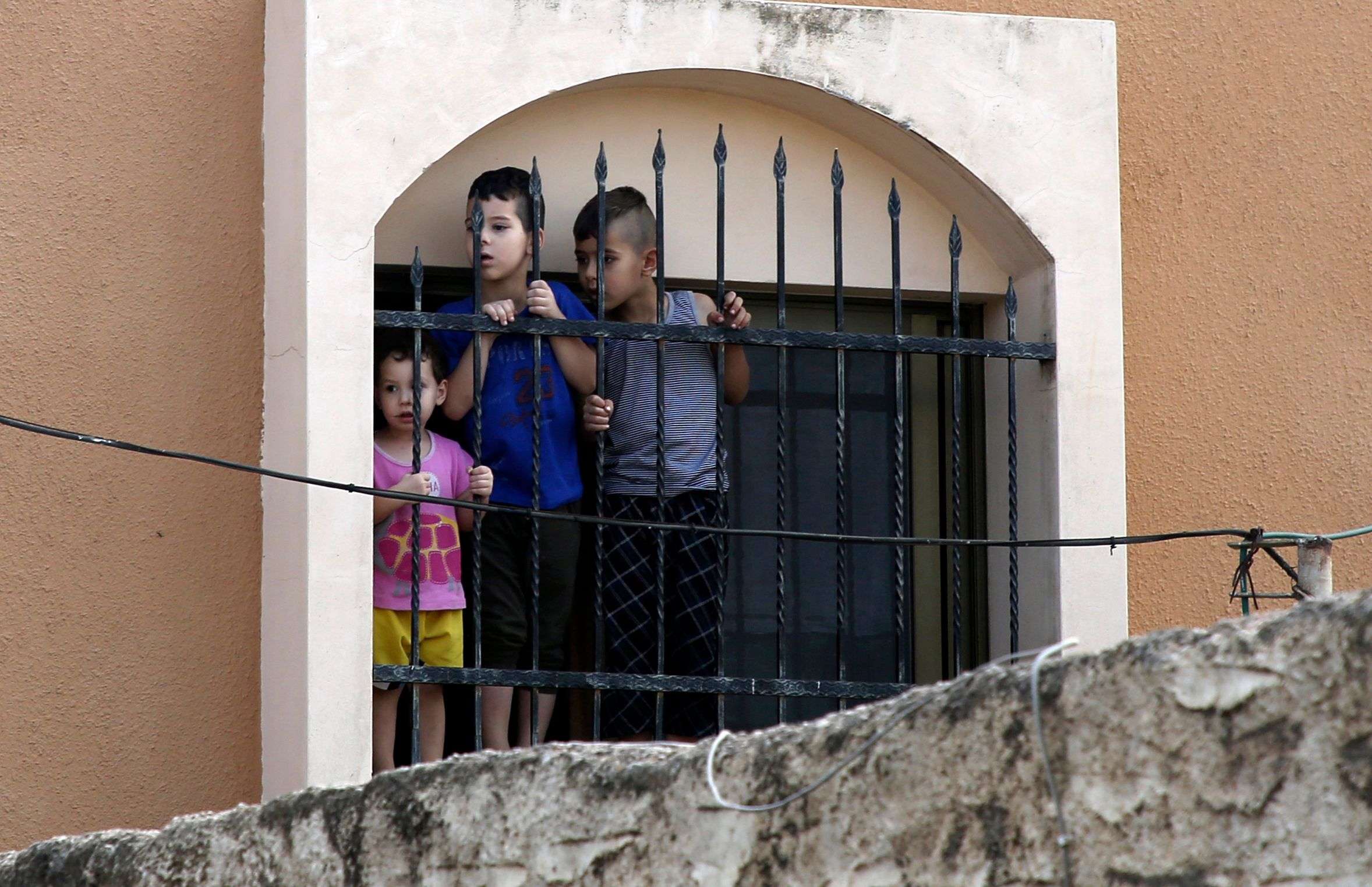 Palestinian children watch the funeral procession of 48-year-old mother of eight, Aisha Rabi, in the West Bank village of Bidya, near Salfit, on October 13, 2018..