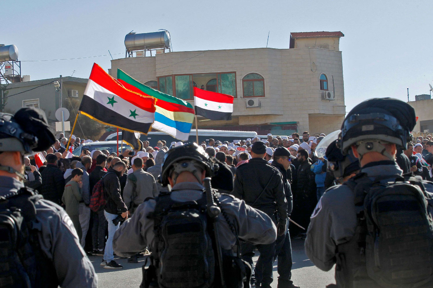 Israeli soldiers stand guard as Druze men protest against municipal elections in front of a polling centre in the village of Majdal Shams in the Israeli-occupied Golan Heights on October 30, 2018.