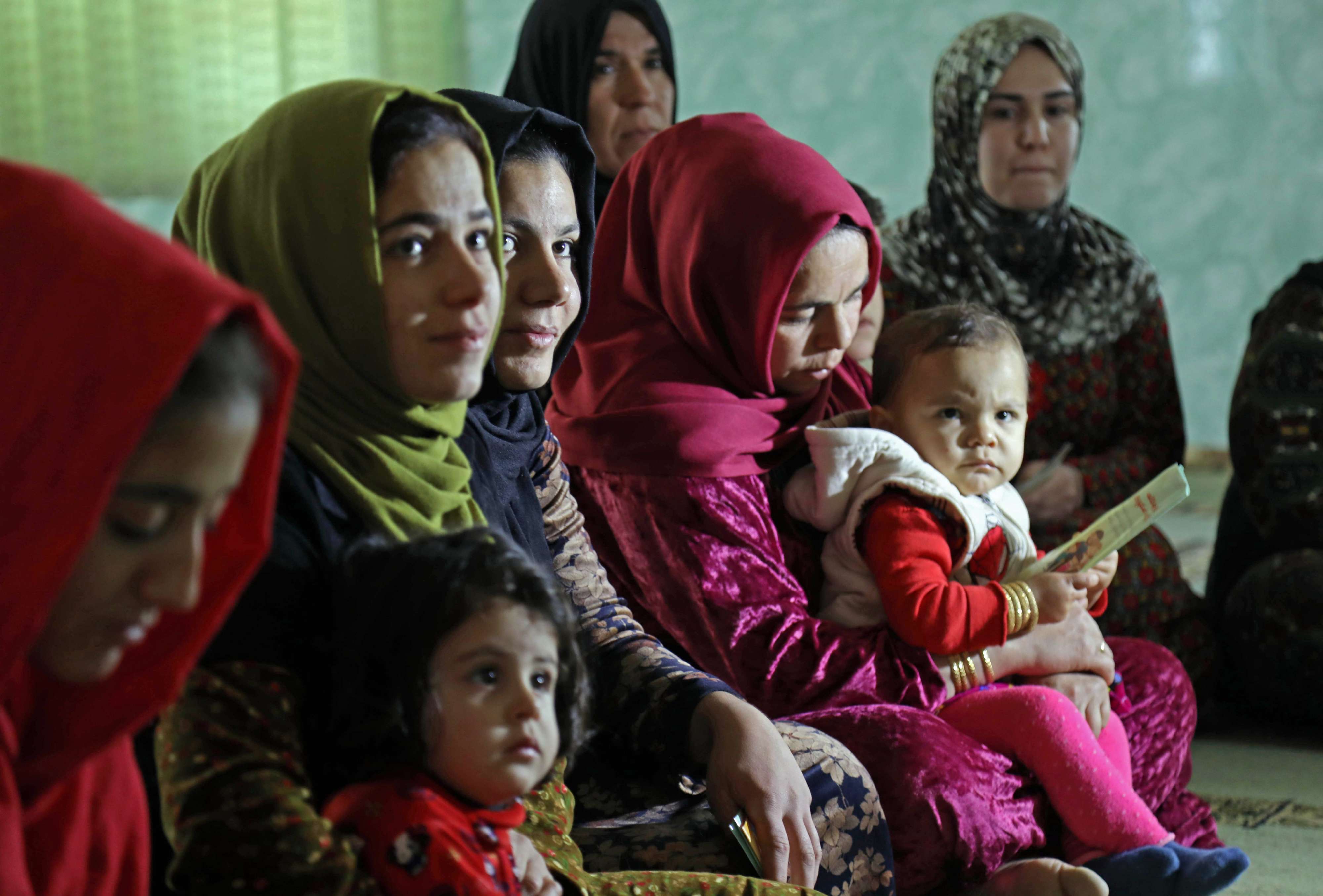 Women and young girls listen to Rasul (not pictured) an Iraqi Kurdish activist with the non-profit organisation WADI, as she peaks about the harms of genital mutilation in Sharboty Saghira, a small village east of regional capital Arbil, on December 3, 2018.