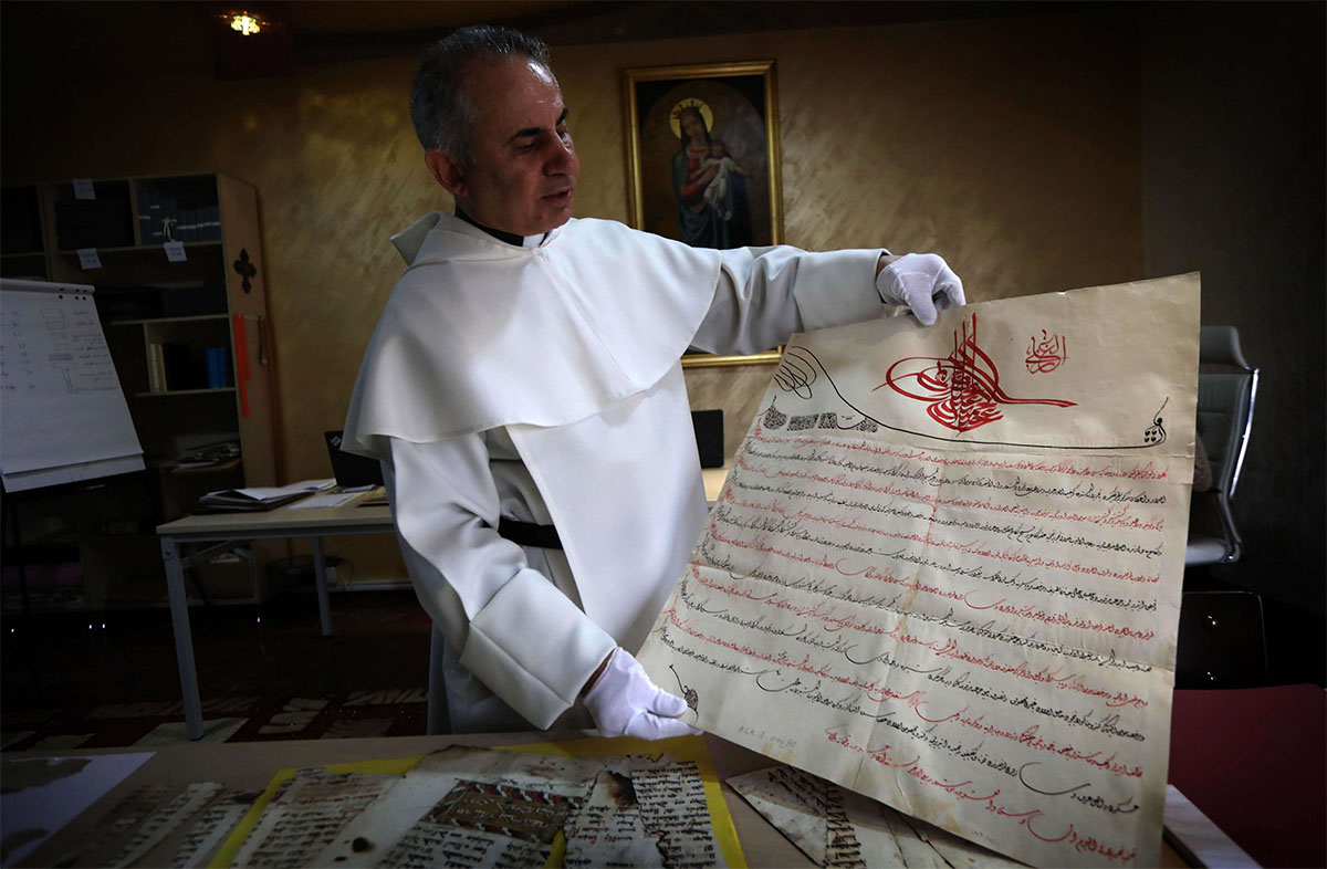 Father Najeeb Michaeel displays a manuscript at the Oriental Manuscript Digitisation Centre (CNDO) in Arbil