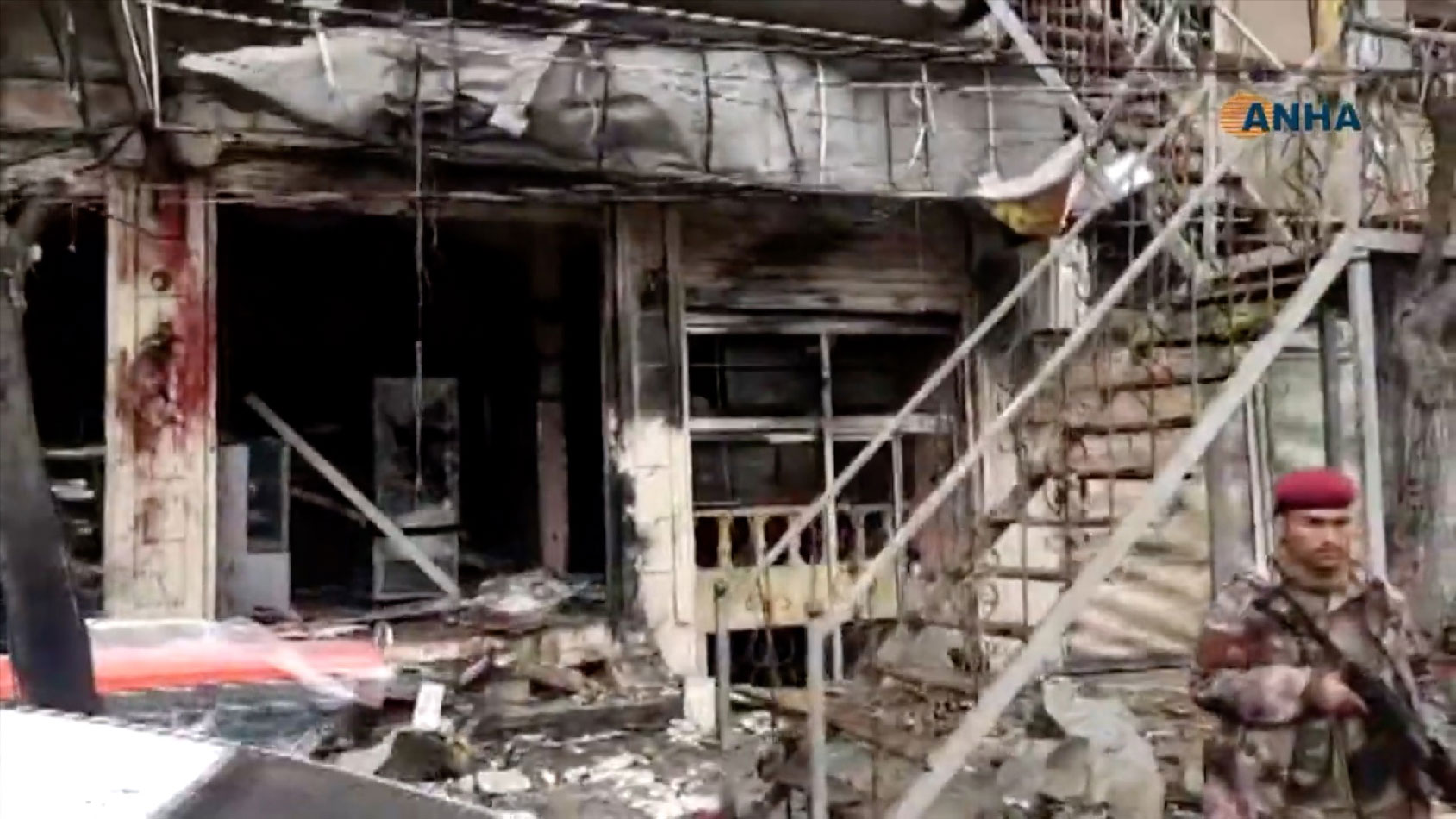 An image grab taken from a video published by Hawar News Agency (ANHA) on January 16, 2019, shows an unidentified member of security forces at the scene of a suicide attack in the northern Syrian town of Manbij.